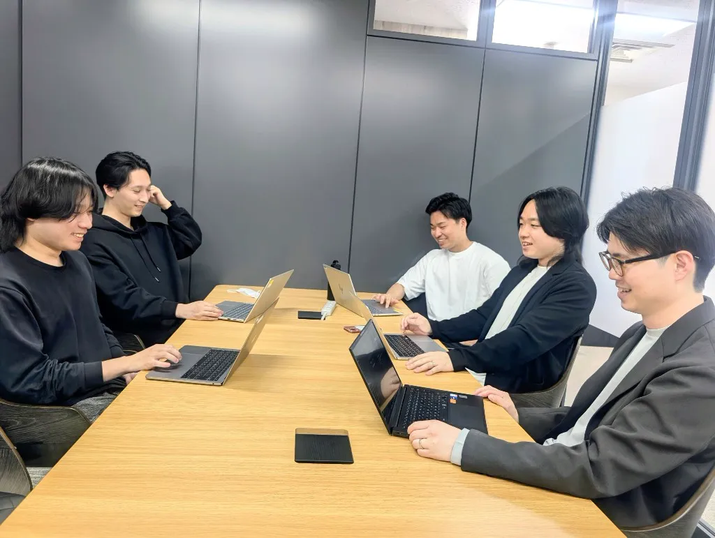オフィスでノートPCに向かうエンジニアチーム